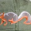 A squirrel is embroidered on the back of an olive green hat.