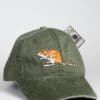 A green hat with an orange and white rat on it.