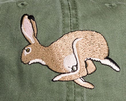 A close up of the side of a hat with a rabbit on it