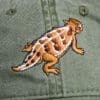 A close up of the lizard on a hat