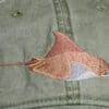 A brown and white fish is on the hat