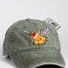 A green hat with an embroidered bird on it.