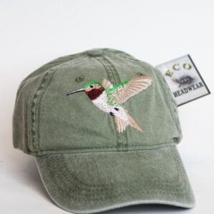 A green hat with a hummingbird on it.