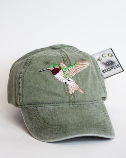 A green hat with a hummingbird on it.