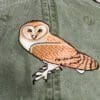 A close up of an owl on the back of a hat