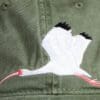 A close up of the back of a hat with an image of a crane.