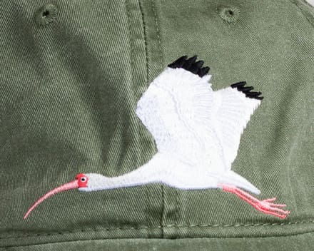 A close up of the back of a hat with an image of a crane.