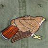 A bird is embroidered on the back of a hat.