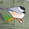 A bird on the branch of a tree embroidered hat.