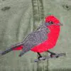 A red bird is embroidered on the back of a hat.