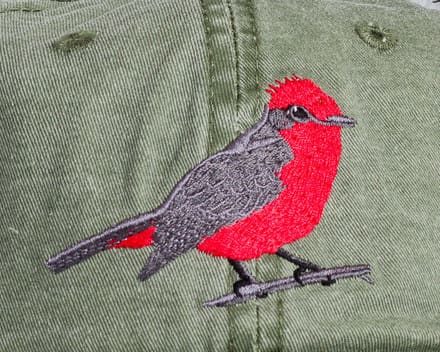 A red bird is embroidered on the back of a hat.