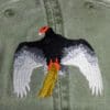 A bird with wings spread and an orange beak.