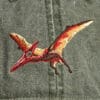A Pileated Woodpecker Cap with a dinosaur embroidered on it.