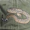 A close up of the snake on a hat
