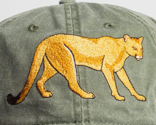 A close up of the back of a hat with an embroidered lion.