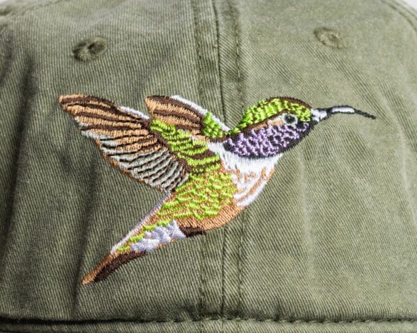 A hummingbird patch is shown on the back of a hat.