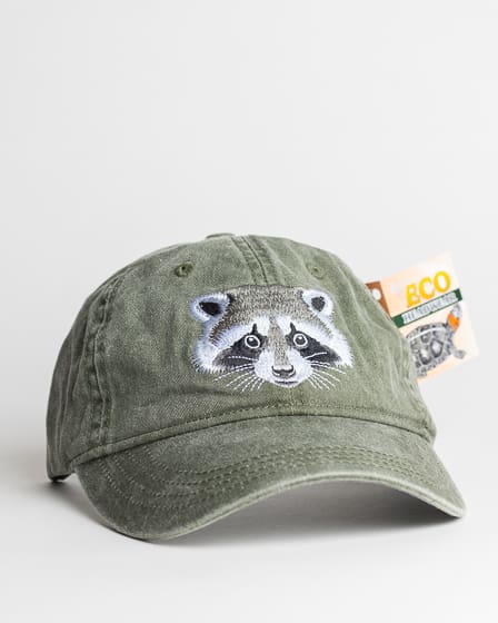 A green hat with an embroidered racoon on it.