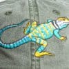 A lizard is painted on the back of a hat.