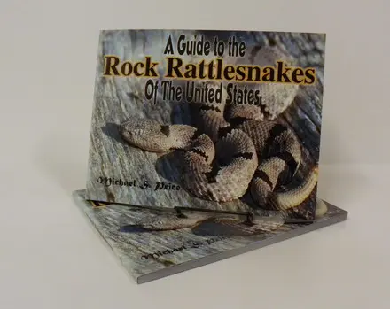 A book about rattlesnakes is shown on top of a table.
