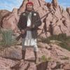 A painting of an indian standing on top of rocks.