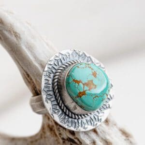 A silver ring with a turquoise stone on top of it.