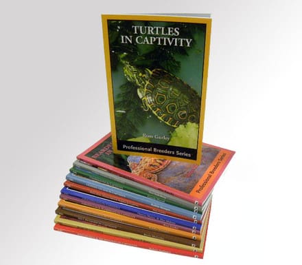 A stack of books with turtles in captivity on them.