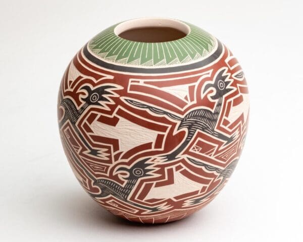 A vase with red, white and green designs on it.