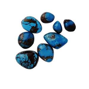 A group of blue stones sitting on top of a white surface.