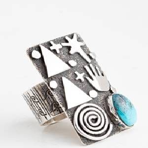 A silver ring with a blue stone and some shapes