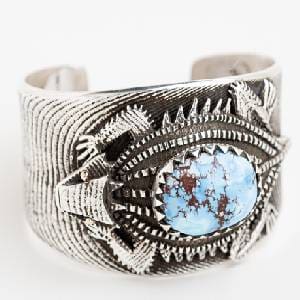 A silver bracelet with a blue stone on it.