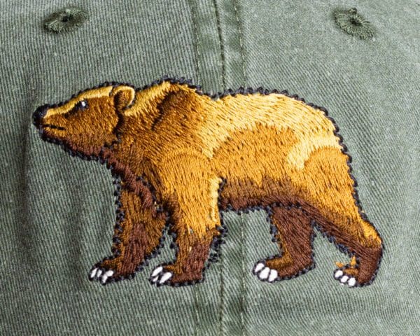 A bear is embroidered on the front of a hat.