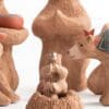 A group of wooden animals sitting on top of a tree.
