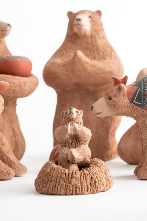 A group of wooden animals sitting on top of a tree.