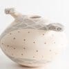 A white vase with two birds on it.