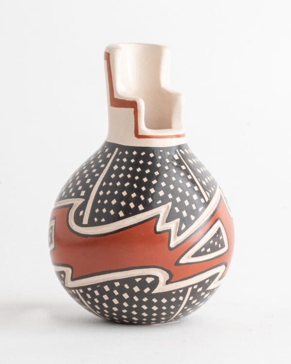 A vase with a red and white design on it.