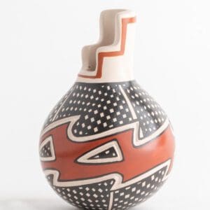 A vase with red and black designs on it.