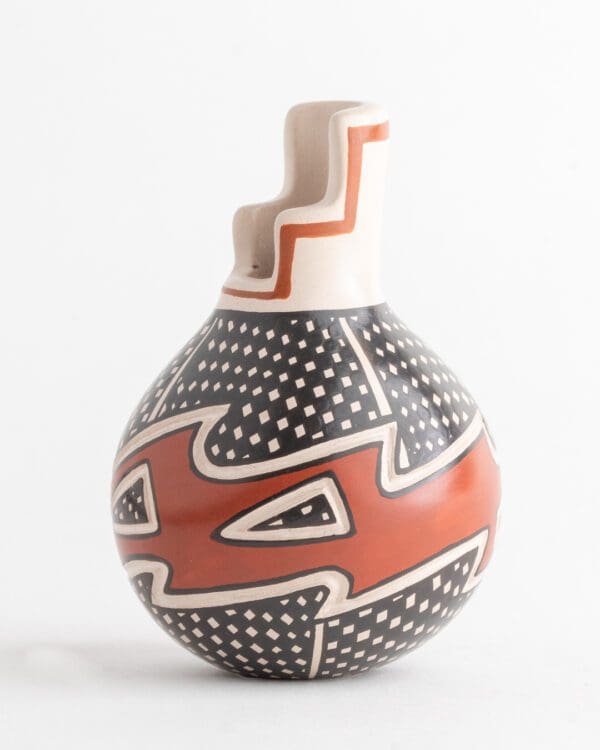 A vase with red and black designs on it.