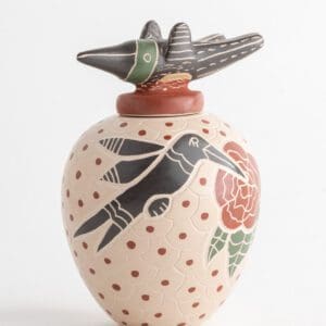 A vase with a bird and flower design on it.