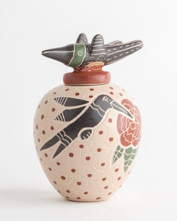 A vase with a bird and flower design on it.