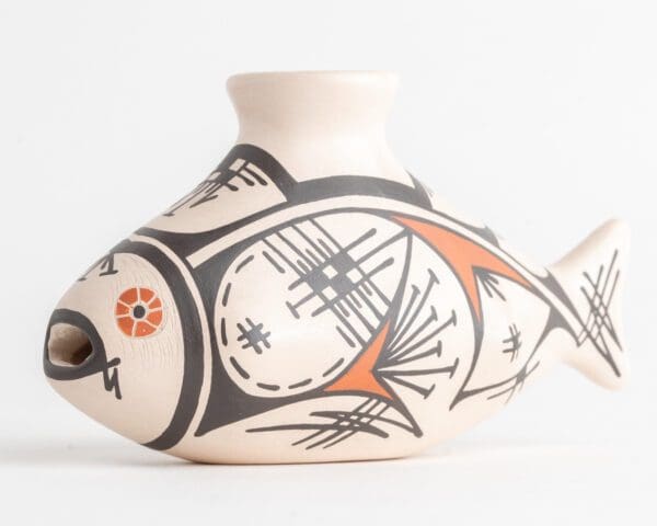 A white vase with black and orange designs on it.