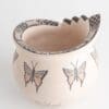 A white vase with butterflies on it.