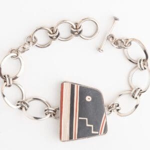 A silver bracelet with a black and red striped design.