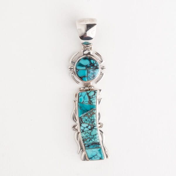 A silver pendant with turquoise and a stone.