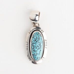 A silver pendant with a blue stone on it.