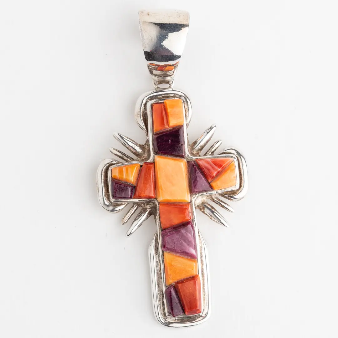 A cross with multiple colors of glass on it.