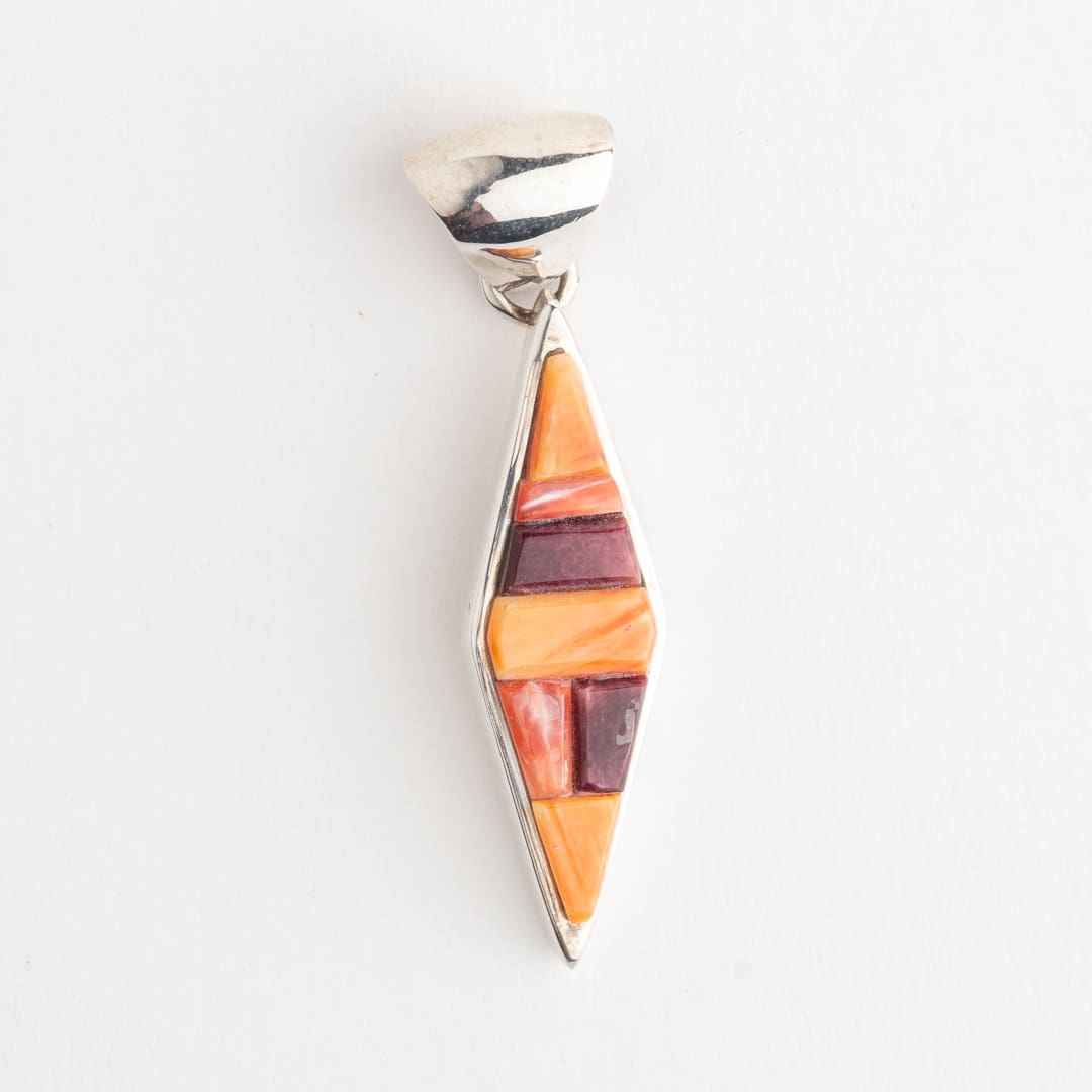 A silver pendant with a colorful piece of art.