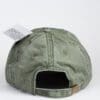 A green hat with a tag on the back of it.