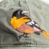 A close up of the back side of a hat with a bird on it