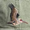 A bird flying in the air with its wings spread.