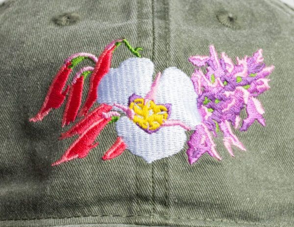 A close up of the flower and plant embroidery on a hat.